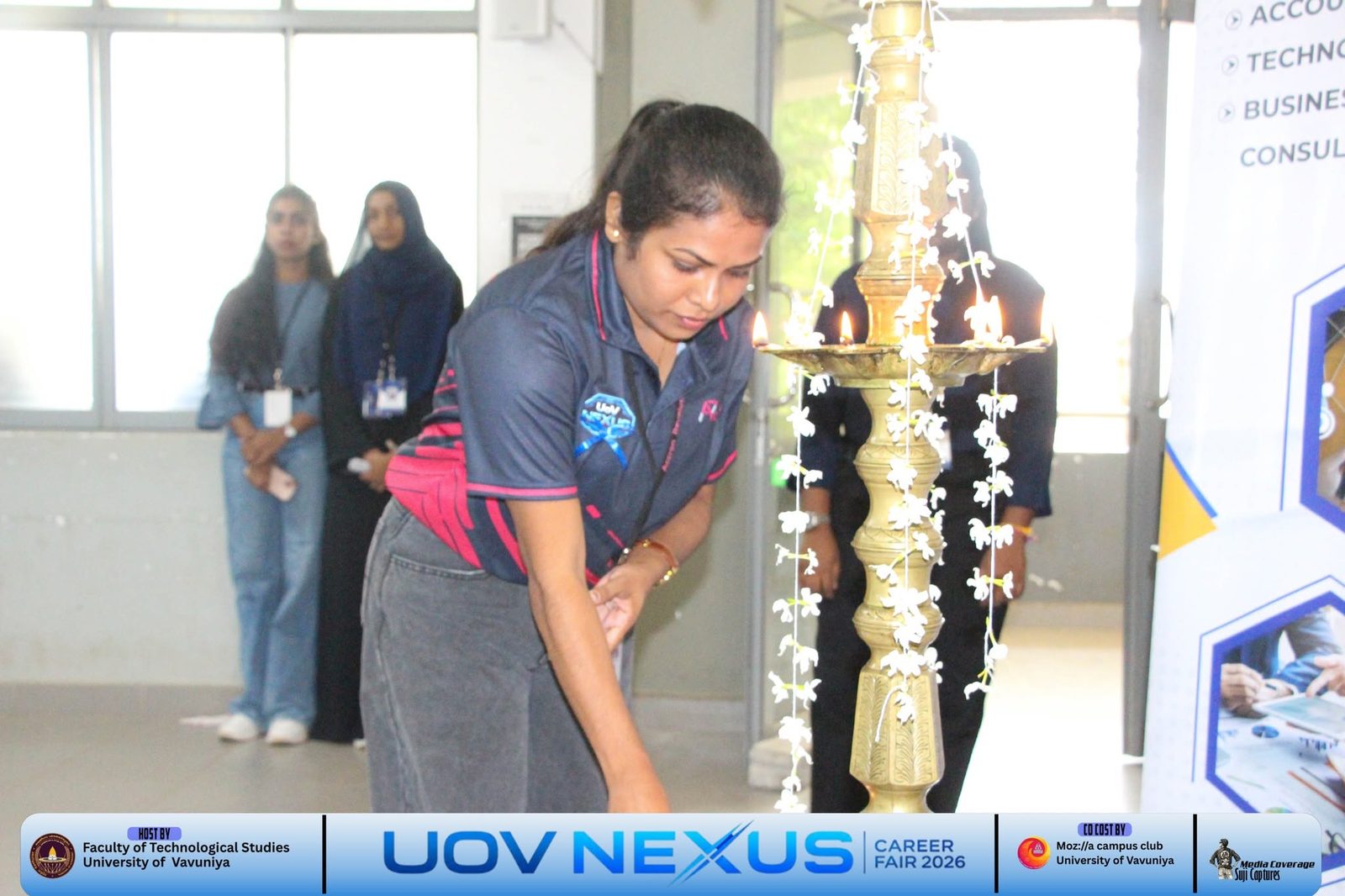 Accron Revolutions team member lighting the oil lamp at the University of Vavuniya Career Fair 2026 opening ceremony